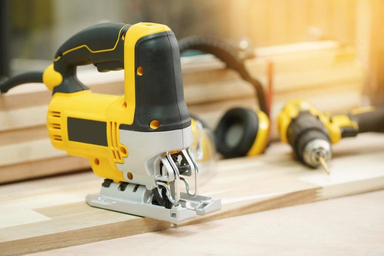 electric-jigsaw-on-walnut-plywood-in-workshop-jigsaw-tool-for-bevel-cuts-in-wood-boards-and-other-materials-woodworking-handicraft-and-diy-concept-selective-focus-free-photo